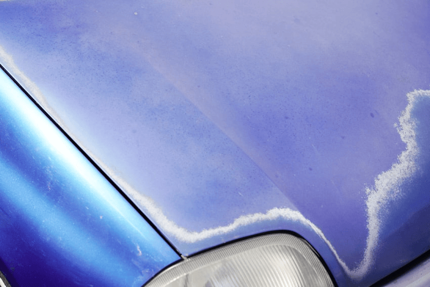 The front hood of a car having a dull and old appearance.